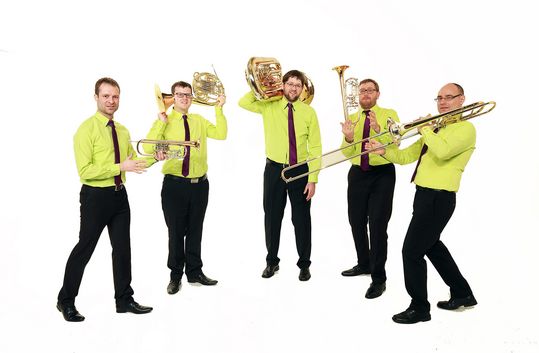 Leipziger Bläserquintett „emBRASSment“ Fünf Männer in gelben Hemden und schwarzen Hosen mit Musikinstrumenten stehen im Halbkreis
